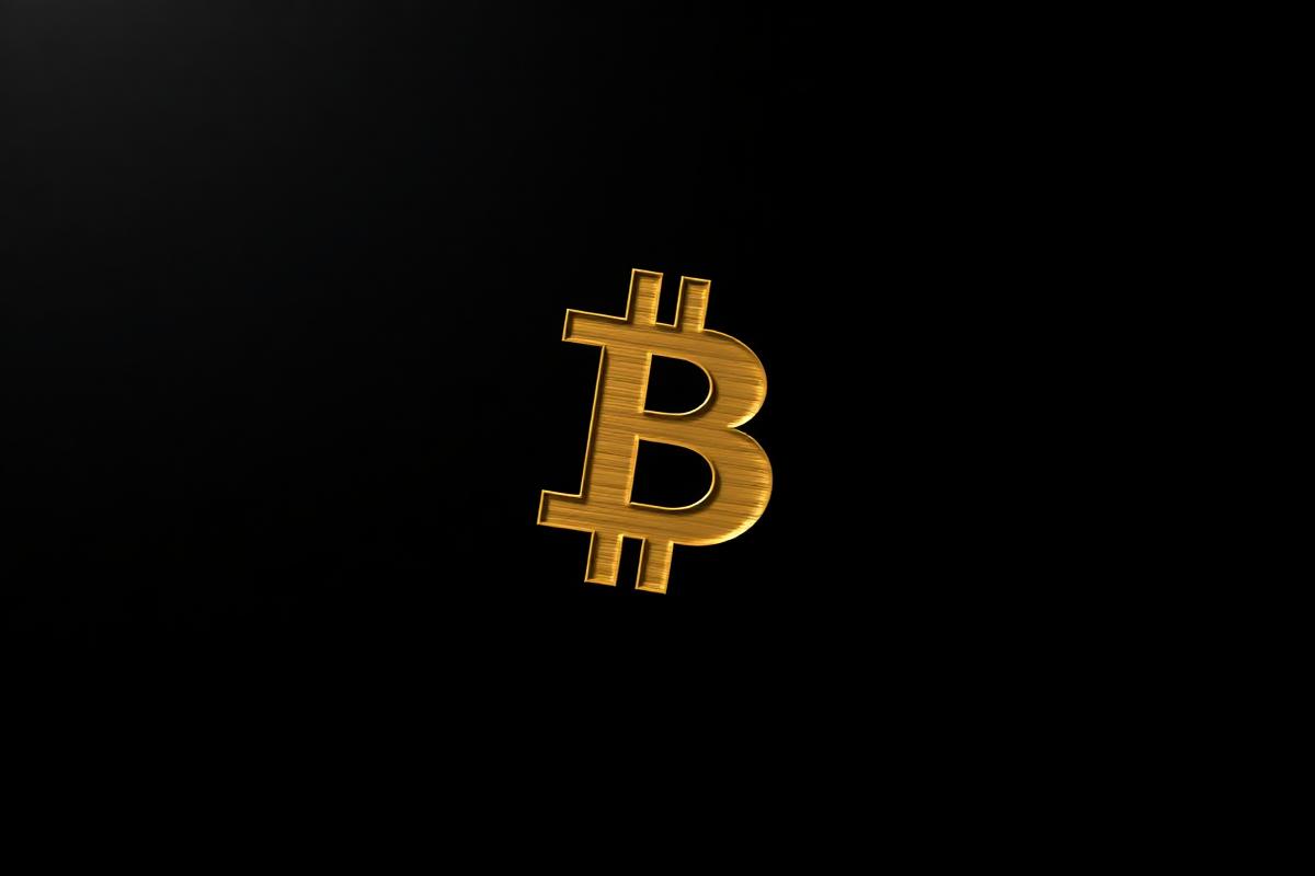Golden brushed-metal Bitcoin symbol on a black background